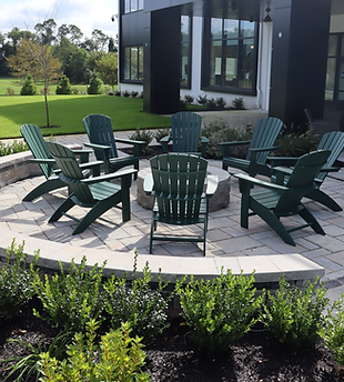 Outdoor fire pit with green Adirondack chairs on a paved patio. | Down To Earth Landscaping | Jackson New Jersey, USA (732) 833-7702