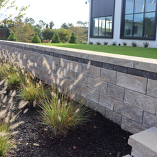 Stone retaining wall with ornamental grasses in front of a modern building. | Down To Earth Landscaping | Jackson New Jersey, USA (732) 833-7702