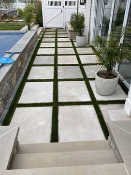 Sleek concrete paver pathway with artificial turf next to swimming pool. Residential landscaping near me| Down To Earth Landscaping | Jackson New Jersey, USA (732) 833-7702