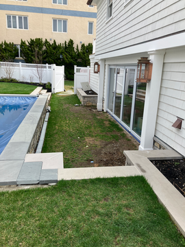 Side of white house, sliding glass door, small grassy area, covered pool. Residential landscaping near me| Down To Earth Landscaping | Jackson New Jersey, USA (732) 833-7702