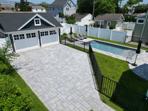 Paved driveway leading to a two-car garage next to a swimming pool. Residential landscaping near me| Down To Earth Landscaping | Jackson New Jersey, USA (732) 833-7702