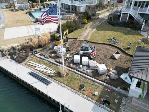 Waterfront residential construction with American flag and heavy machinery. Residential landscaping near me| Down To Earth Landscaping | Jackson New Jersey, USA (732) 833-7702