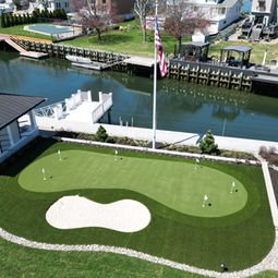 Aerial view of backyard putting green, sand trap, American flag, canal. | Down To Earth Landscaping | Jackson New Jersey, USA (732) 833-7702