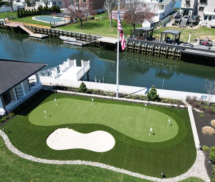 Aerial view of waterfront home with putting green, sand trap, and canal. Residential landscaping near me| Down To Earth Landscaping | Jackson New Jersey, USA (732) 833-7702