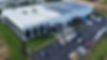 Spacious modern white commercial building, solar panels, parking lot, green lawn. Hardscape installation | Down To Earth Landscaping | Jackson New Jersey, USA (732) 833-7702