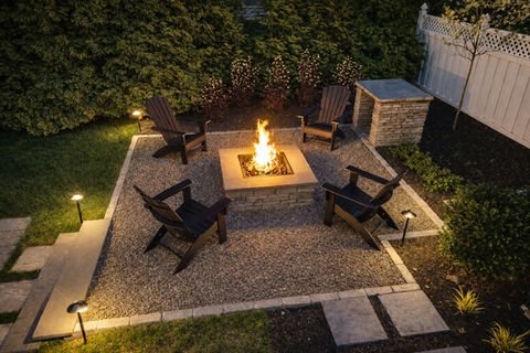 Outdoor fire pit with four Adirondack chairs on a gravel patio. Residential landscaping near me| Down To Earth Landscaping | Jackson New Jersey, USA (732) 833-7702